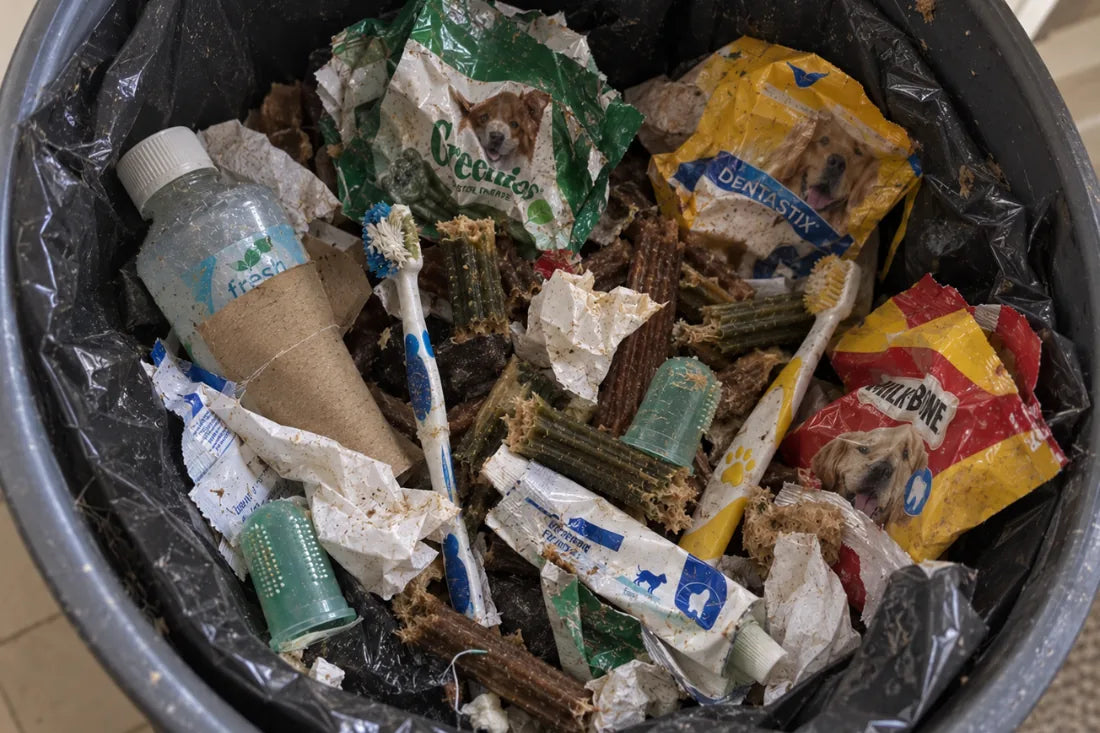 Discarded dental chews, a cracked antler and an unused toothbrush in an open trash bin
